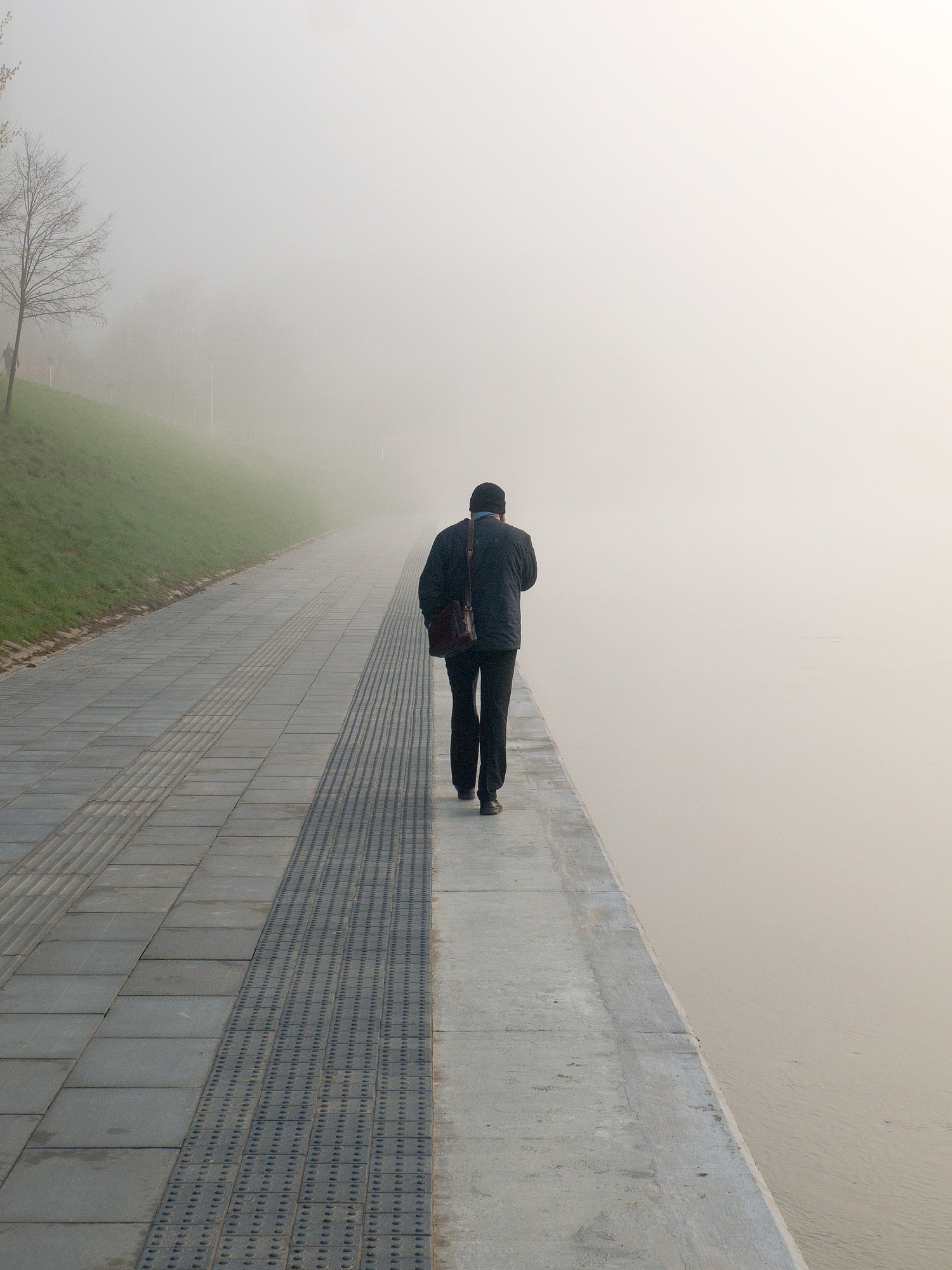 Mysterious man walking alone in the mist along the river